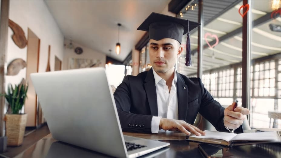 Recent graduate working on a laptop, laying the foundation for their first business